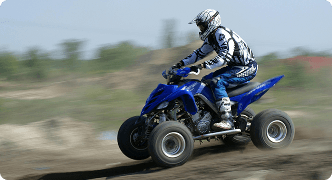 Person riding an ATV on dirt terrain representing ATV insurance coverage